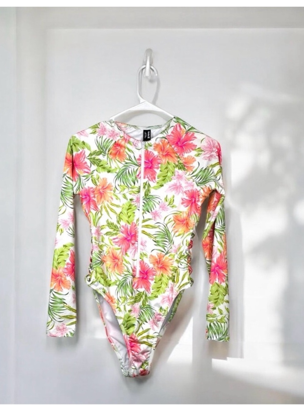 Hurley Malibu floral long sleeve zip-front one-piece swimsuit.